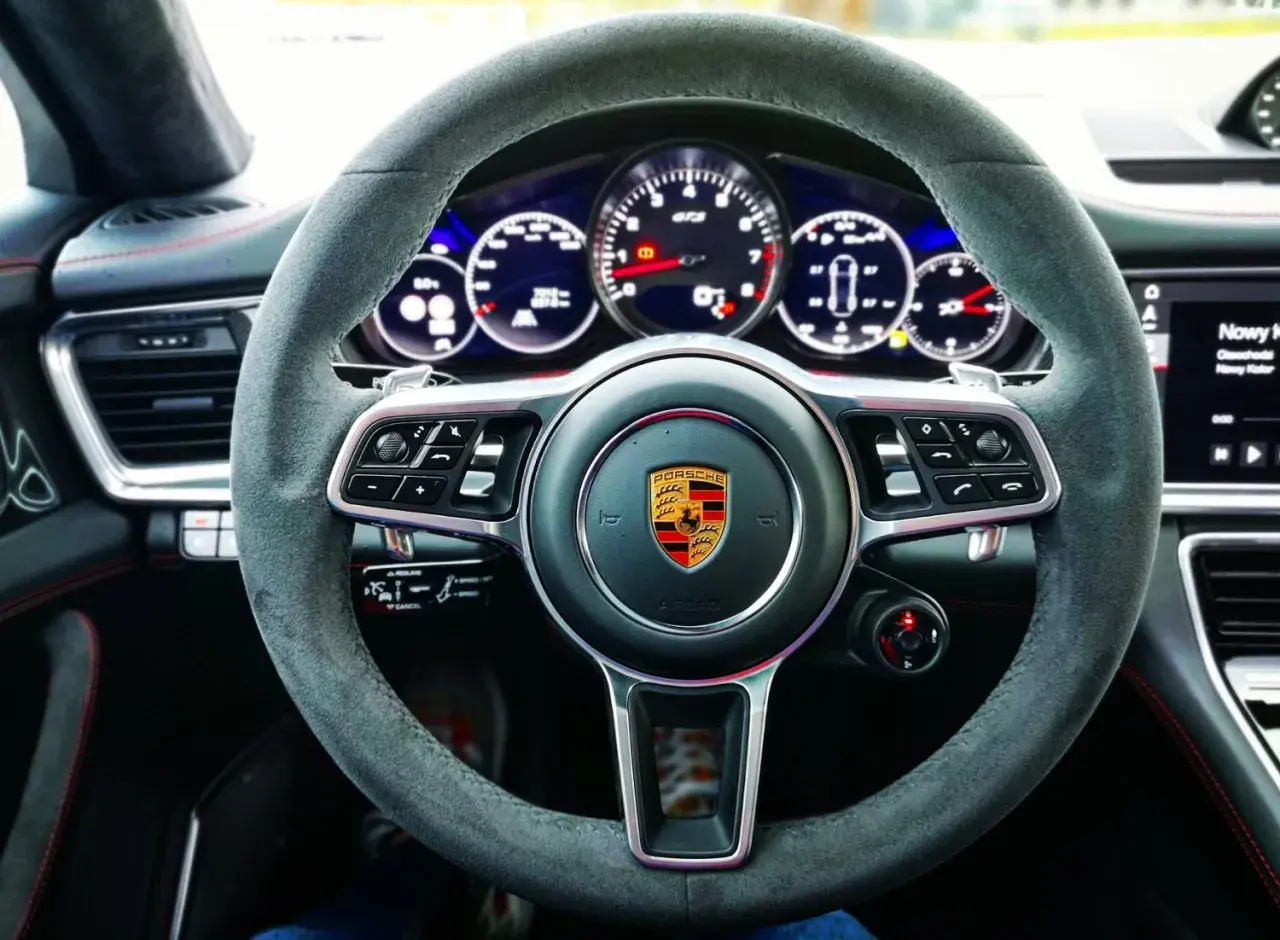 Kierownica Porsche Panamera GTS z alcantary, z emblematem Porsche i wskaźnikami GTS.