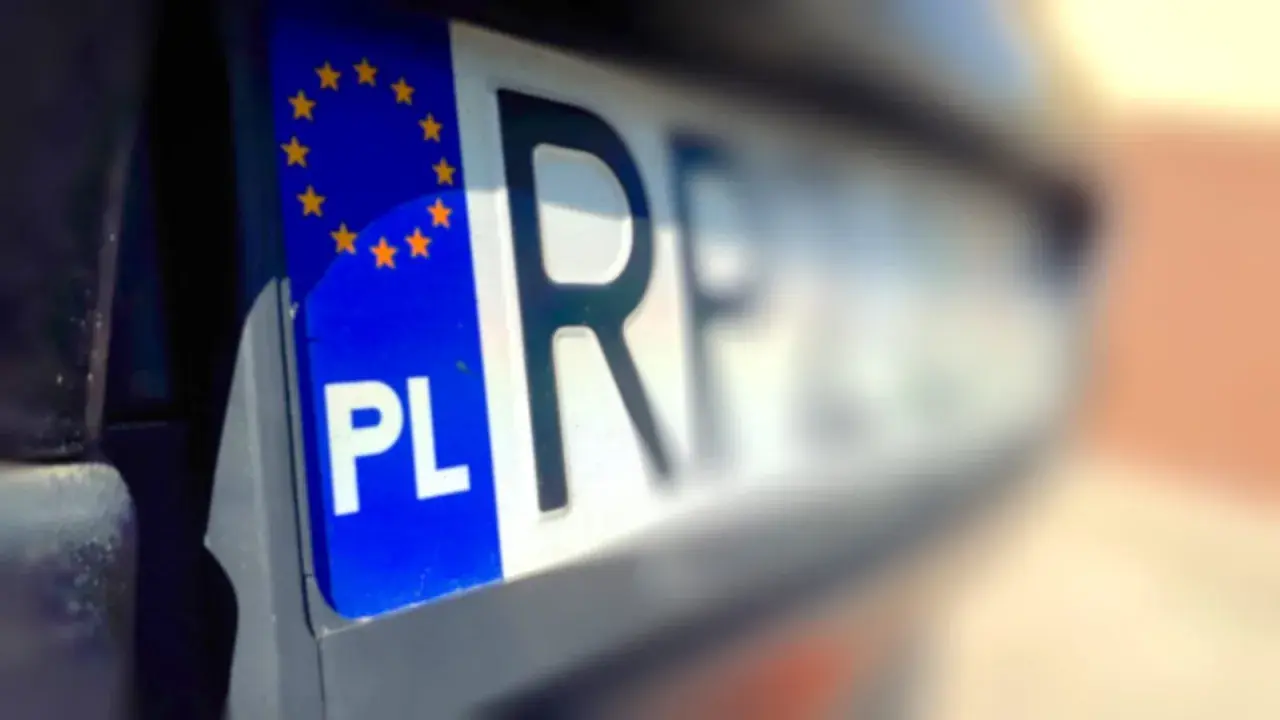Fragment polskiej tablicy rejestracyjnej z symbolem UE i literami "PL". Wygląda jak tymczasowy dowód rejestracyjny.