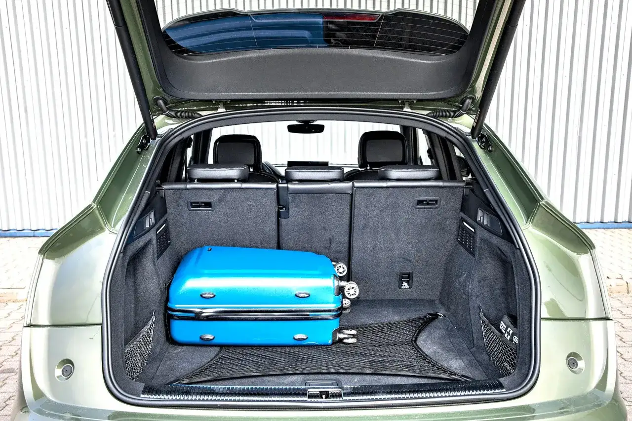 Bagażnik Audi Q5 Sportback 2025 gotowy na podróż. Błękitna walizka czeka na załadunek.