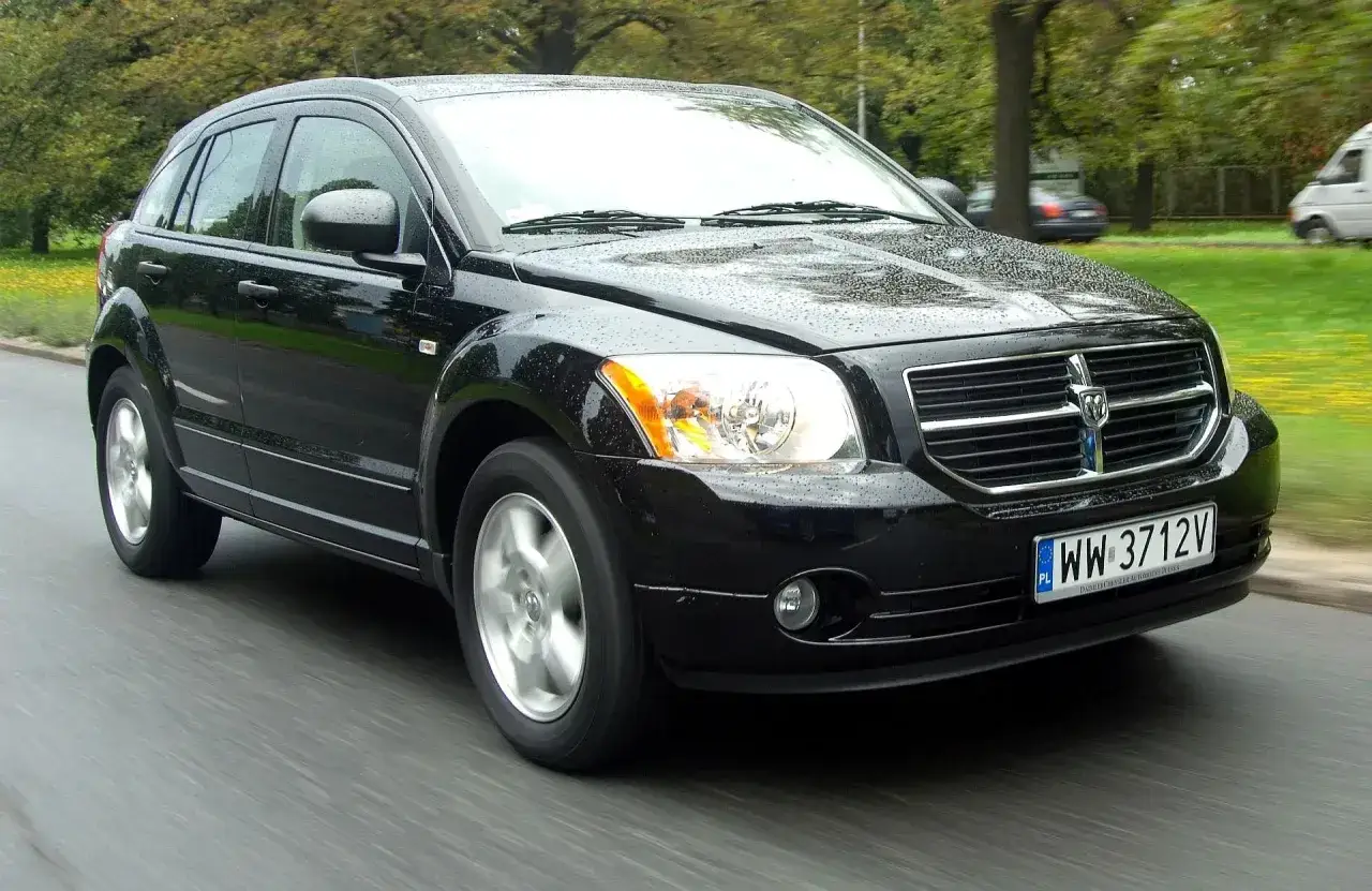 Czarny Dodge Caliber w ruchu. Wiele osób szuka dodge caliber opinie przed zakupem.