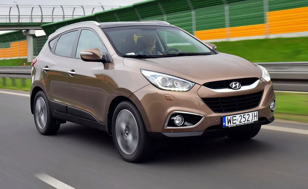 Brązowy Hyundai ix35 jedzie autostradą.