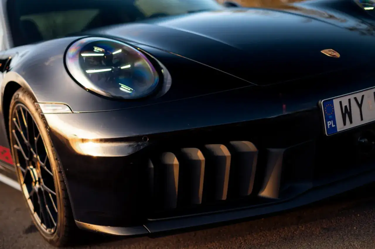 Czarny Porsche 911 GTS z charakterystycznymi wlotami powietrza i reflektorami LED.